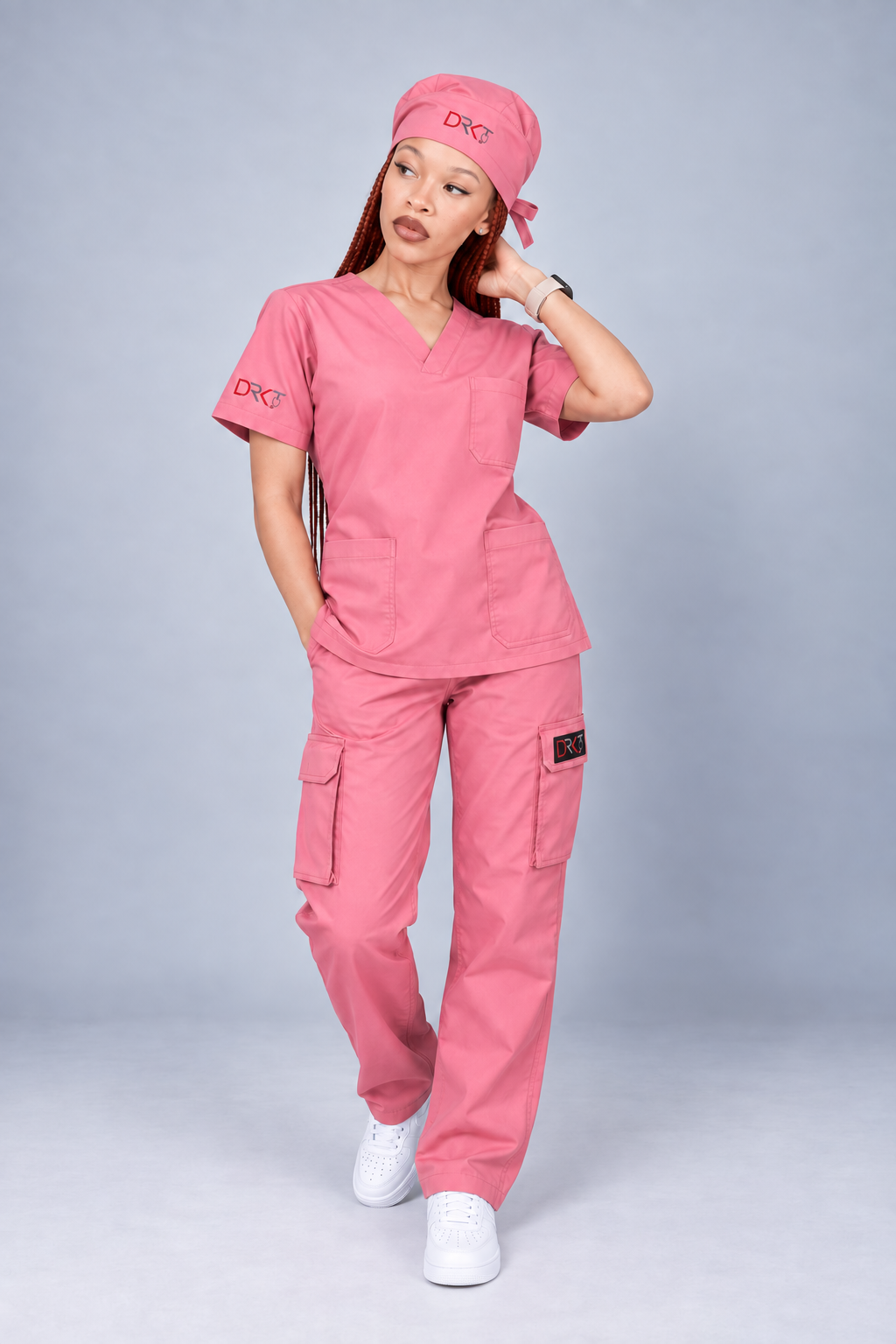 The same DRKT model wearing pink scrubs and a matching scrub cap